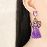 Elegant purple tassel earrings featuring gold and purple crystals, designed as fringe drop earrings with cubic zirconia accents.
